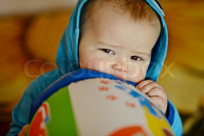 Baby biting toy in soft selective focus | Stock image | Colourbox
