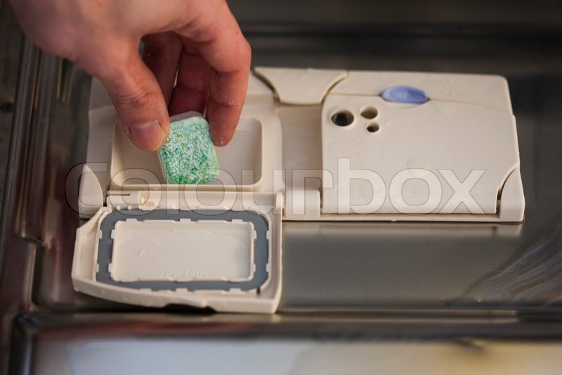 A man putting soap in the dishwasher Stock image Colourbox