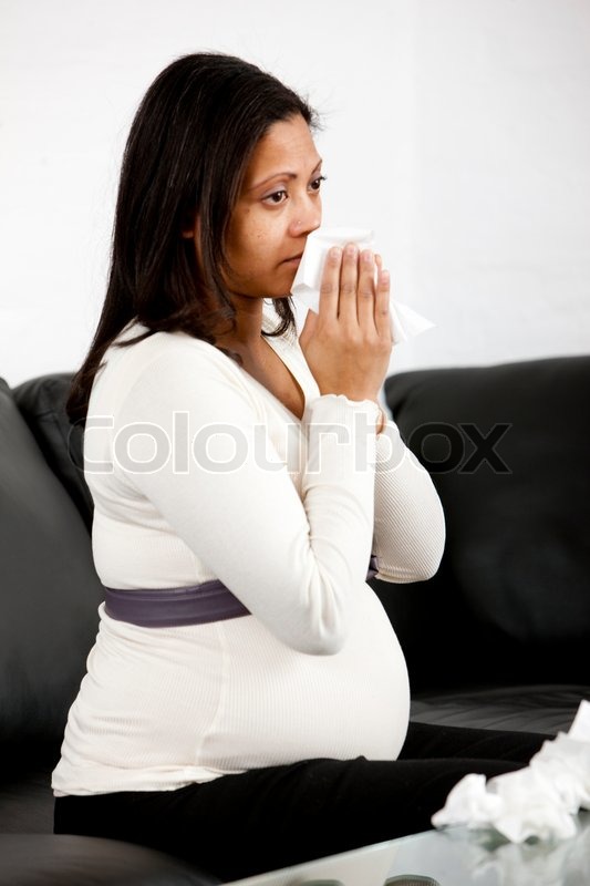 A crying pregnant woman on a sofa | Stock Photo | Colourbox