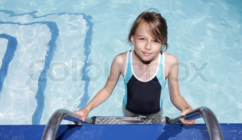 A ten year old blonde girl standing on the ladder to a swimmingpool | Stock  image | Colourbox