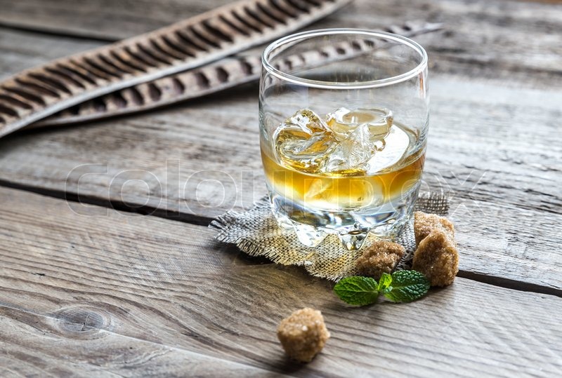 Glass of rum on the wooden background | Stock image | Colourbox