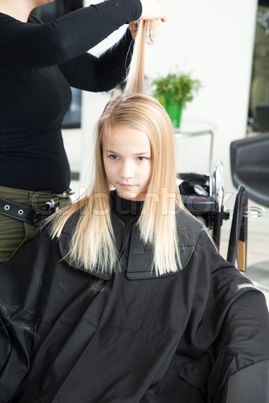 A Young Girl Getting A New Haircut In A Stock Image