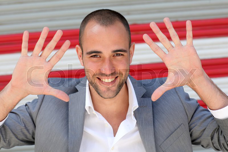 Attractive man showing hand palms to Stock image Colourbox
