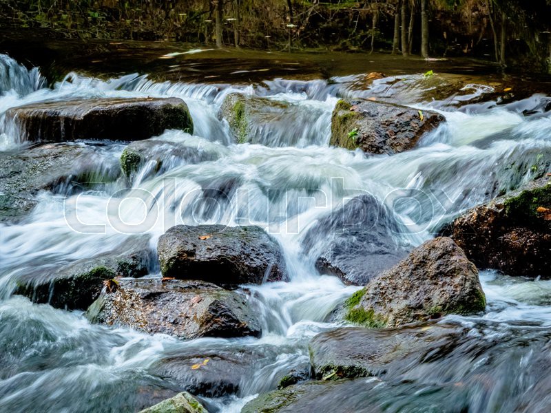 A creek with rocks and flowing water. Stock image Colourbox