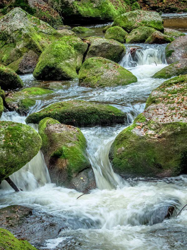 A creek with rocks and flowing water. Stock image Colourbox