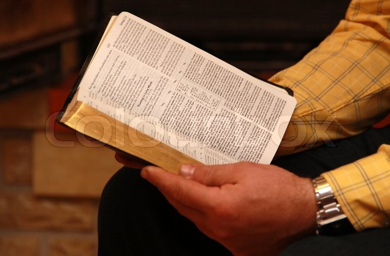 A man reads the Bible at home sitting Stock image Colourbox