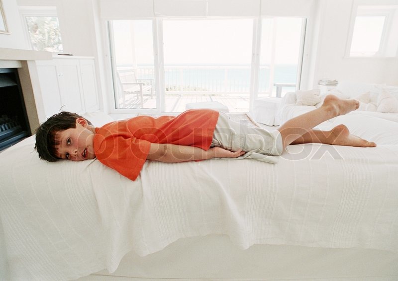 ©Téo Lannié/AltoPress/Maxppp ; Boy on bed lying on stomach Stock