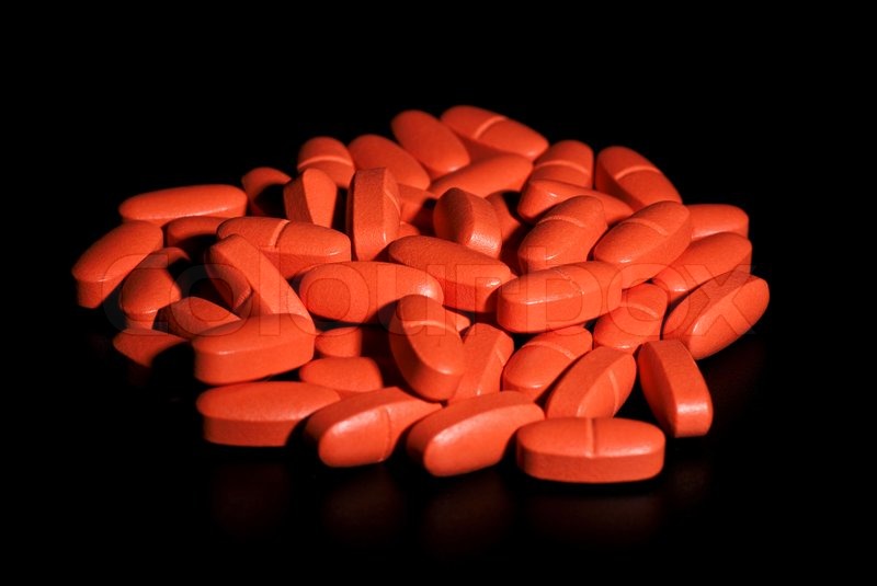 Batch of red pills isolated on black | Stock Photo | Colourbox