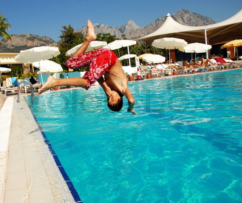 Boy jumping into swimming pool Stock image Colourbox