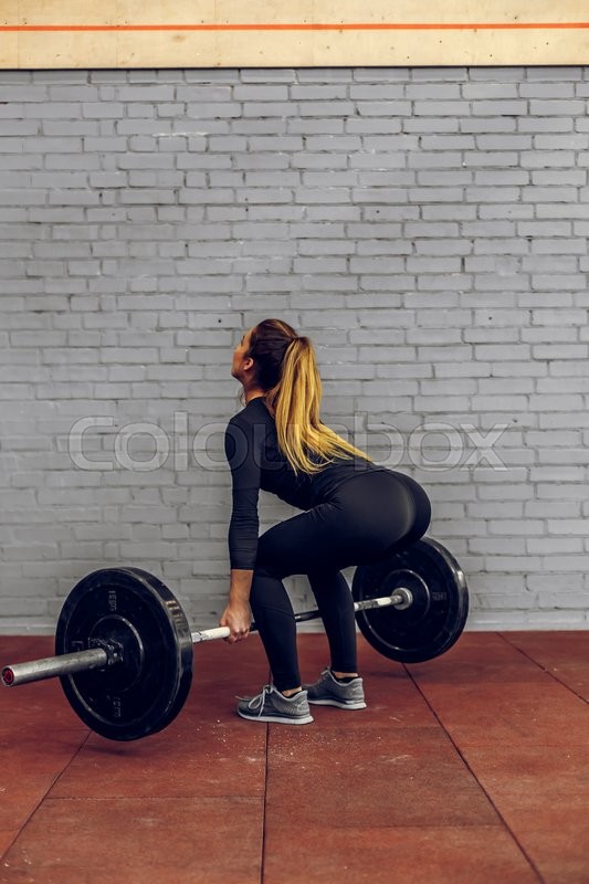 Strong young woman lifting heavy Stock image Colourbox