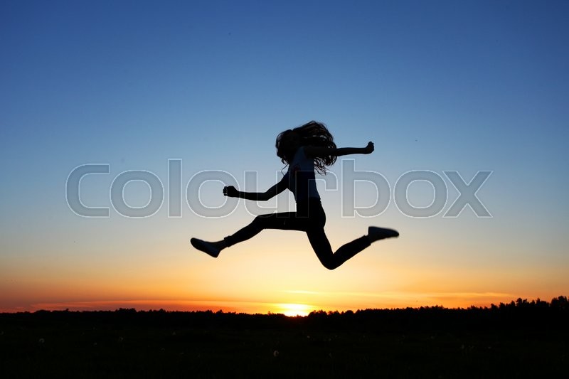 Silhouette of female jumper in sunset | Stock image | Colourbox