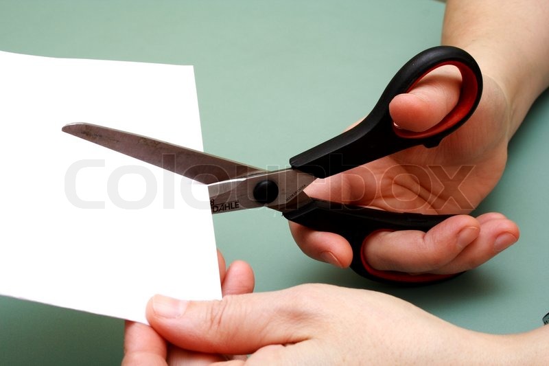 Women hand is cutting paper with scissors | Stock Photo | Colourbox