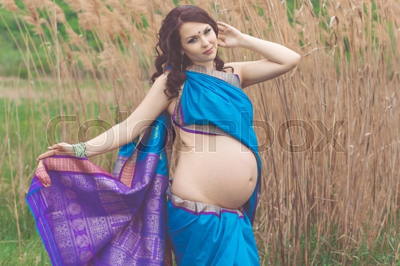 Pretty pregnant girl is wearing blue fashion indian sari 