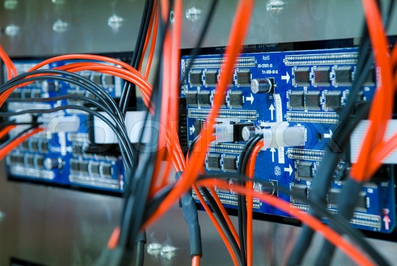 Closeup of two blue circuit boards, with red and black wires ...