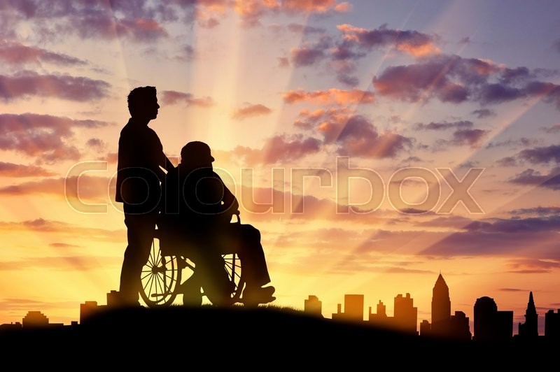 concept of disability and old age silhouette of a man looking after a disabled person on a background of city sunset stock photo colourbox
