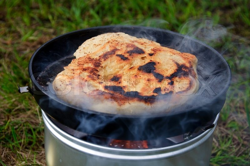 Baking bread outdoor on a camping stove Stock image Colourbox