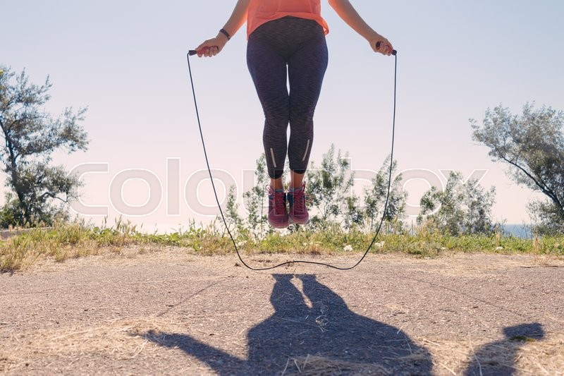 Female feet in sneakers jumping on a Stock image Colourbox