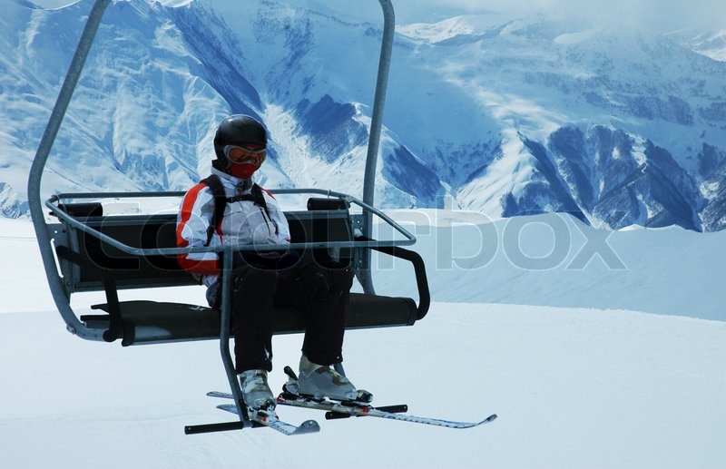 Skier on chair lift at ski resort Stock Photo Colourbox