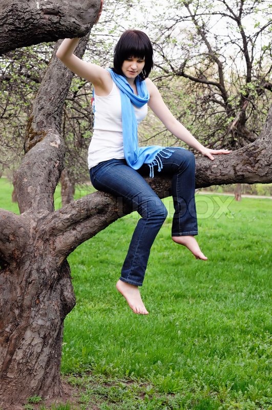 girl sitting against tree