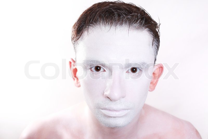 Portrait of young brunette man with white makeup on skin 