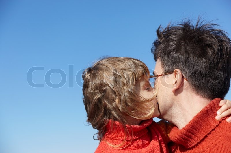 daughter kissing father on blue sky background stock photo colourbox