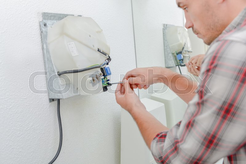 Electrician repairing hand dryer Stock image Colourbox
