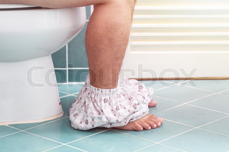 Man sitting on a toilet seat in the Stock image Colourbox