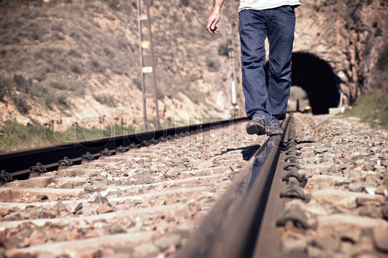 Young man doing balances on a train ... | Stock image | Colourbox