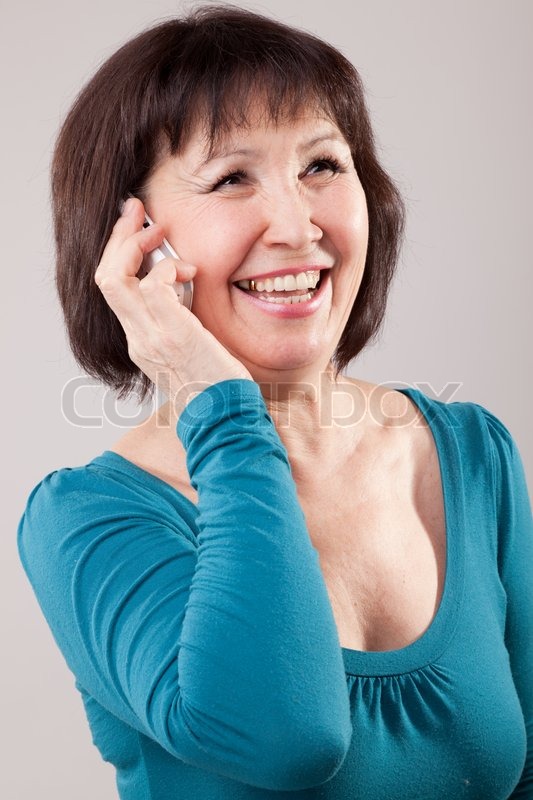 Mature beautiful woman using a mobile phone | Stock Photo | Colourbox