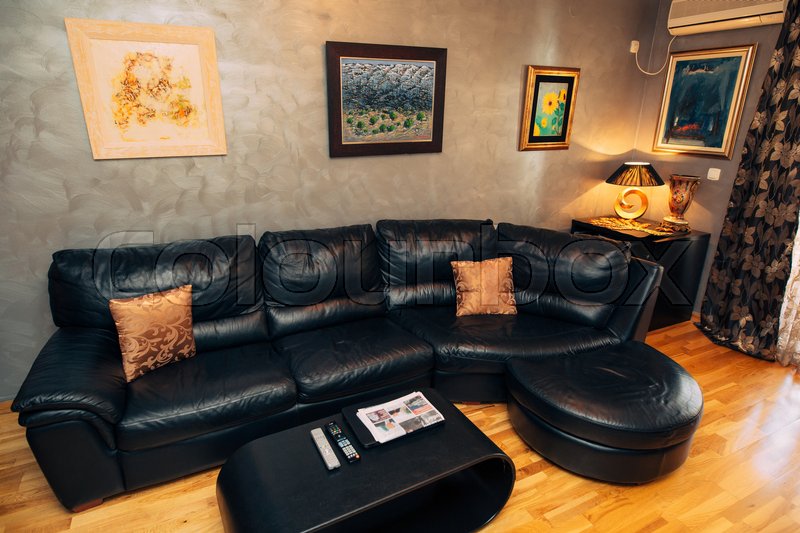 Black leather sofa in the apartment. Stock image Colourbox
