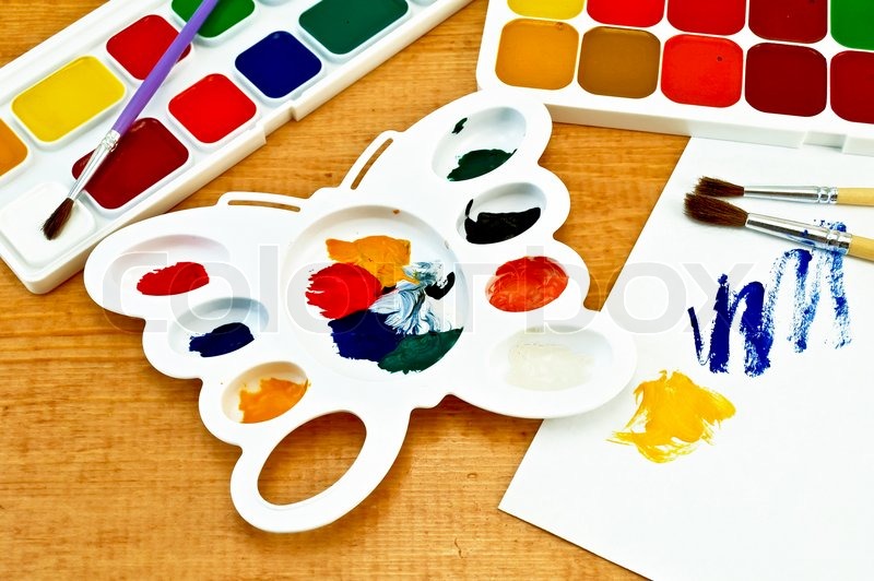 two boxes of paint three brushes white palette in the shape of a