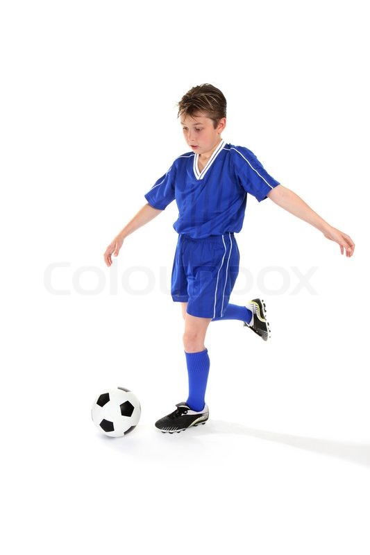 a boy kicks a soccer ball some slight motion stock photo colourbox