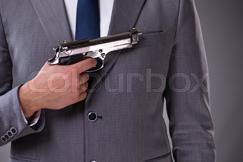 Businessman pulling the gun out of Stock image Colourbox