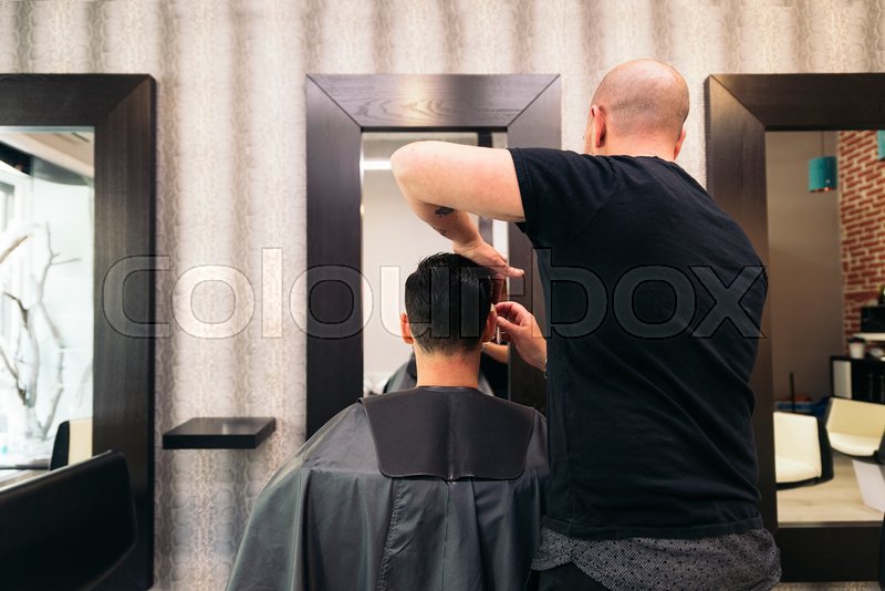 Hairstylist making men's haircut to an Stock image Colourbox