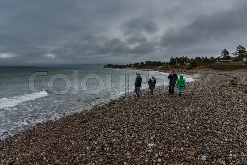 En familie går tur på stranden på en ... | Stock foto | Colourbox