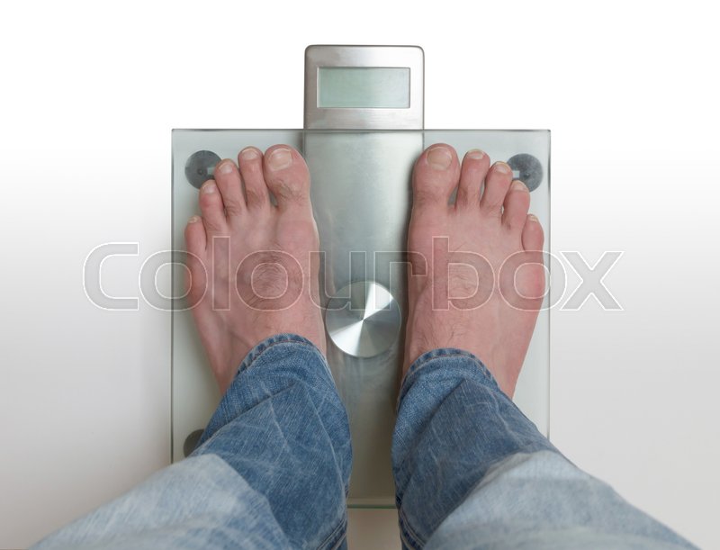 Closeup of man’s feet on weight scale - | Stock image | Colourbox