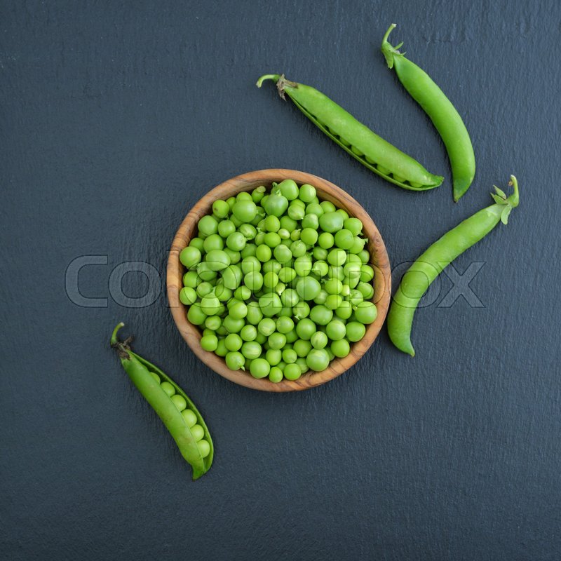 Green peas in wooden bowl on black | Stock image | Colourbox