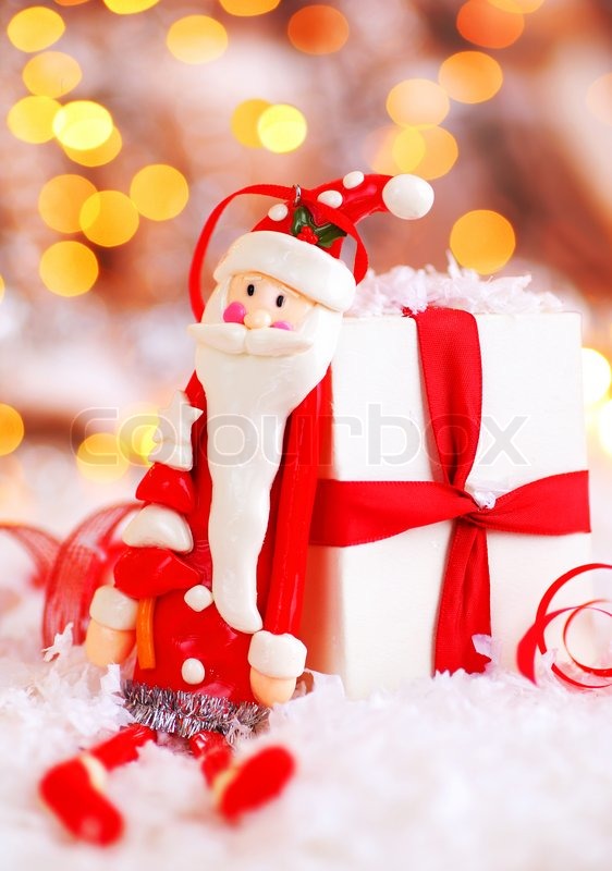 Holiday background with cute Santa Claus Christmas tree decorative ornament  & gift box in snow over abstract defocus lights | Stock image | Colourbox