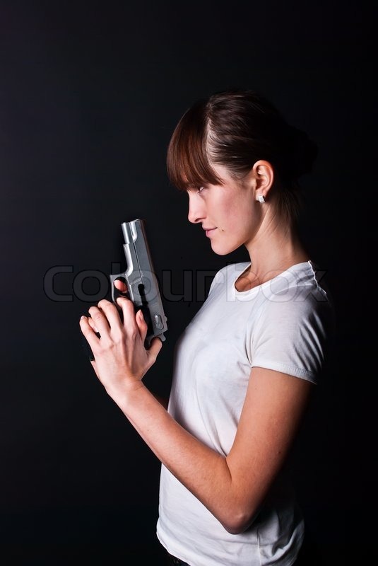 Woman with gun on black background | Stock image | Colourbox