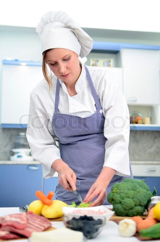 attractive chief cook preparing food cuts broccoli stock photo