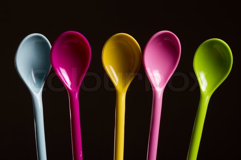 Spoons of different colors on even | Stock image | Colourbox