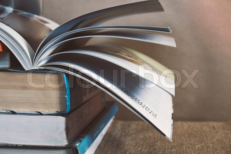 Open book on top of old textbook stack Stock image Colourbox