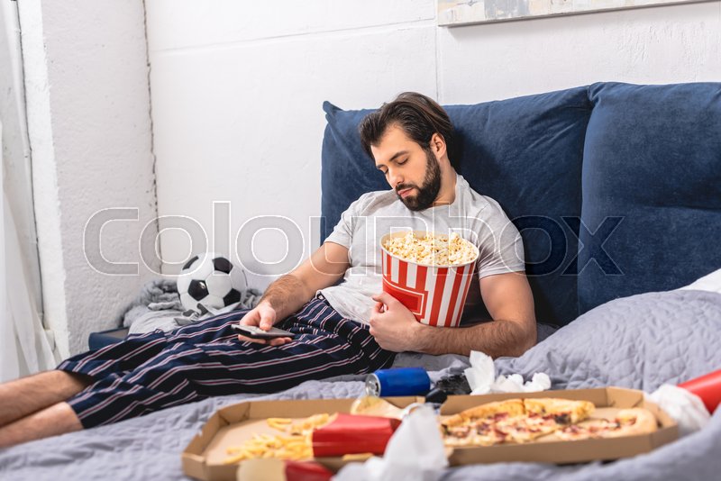 Handsome loner sleeping with popcorn Stock image Colourbox