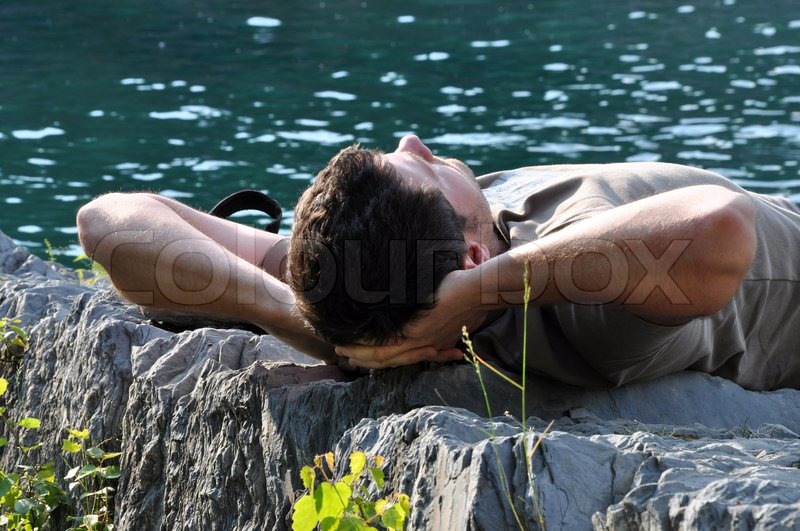 Sleeping man relax by the water Stock Photo Colourbox