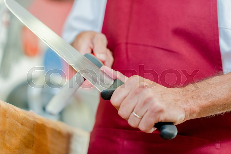 Man sharpening a knife Stock image Colourbox
