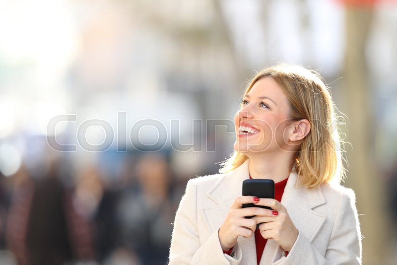 Happy Woman Looking At Side Holding Smart Phone Standing In The Street Stock Images Page Everypixel
