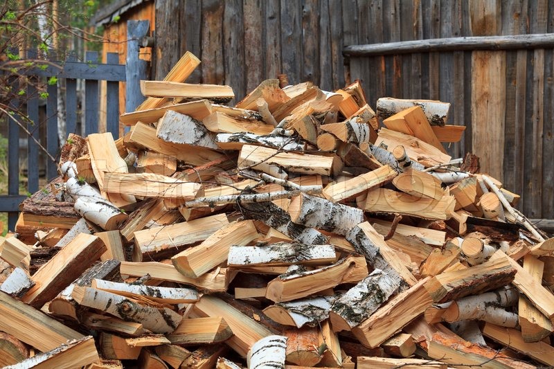 Chain Saw Against Firewood Pile Pile Of Firewood Against Wooden Stock Photo