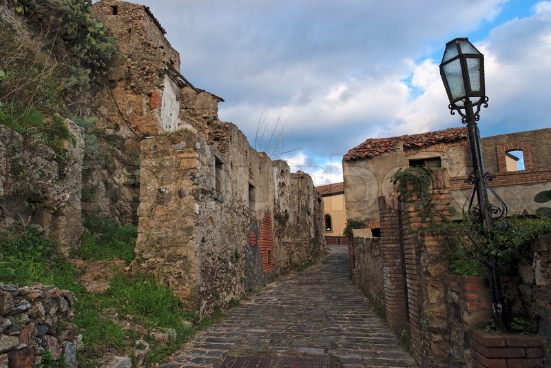 Paved medieval street with ruined house in Savoca village, Sicily