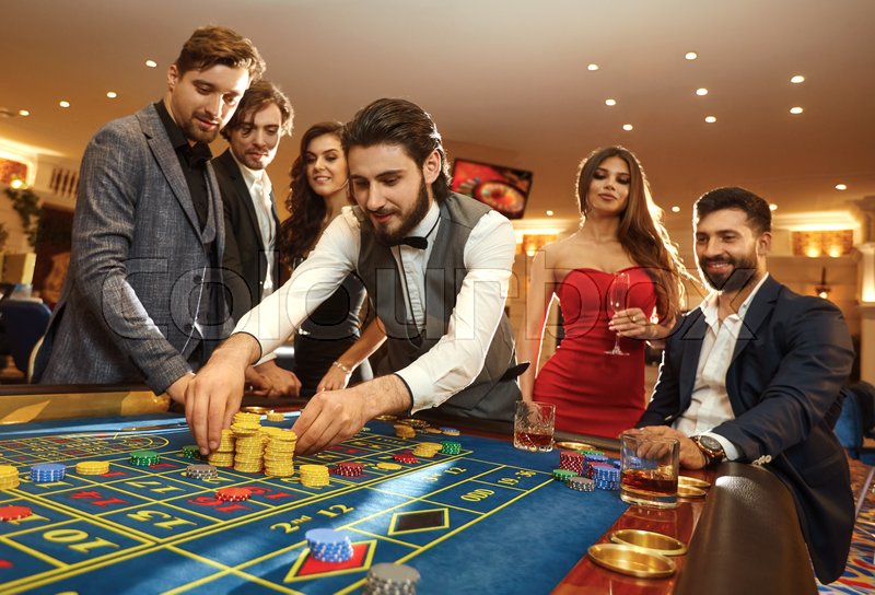 A young man with friends makes bets on roulette in a casino. | Stock image  | Colourbox