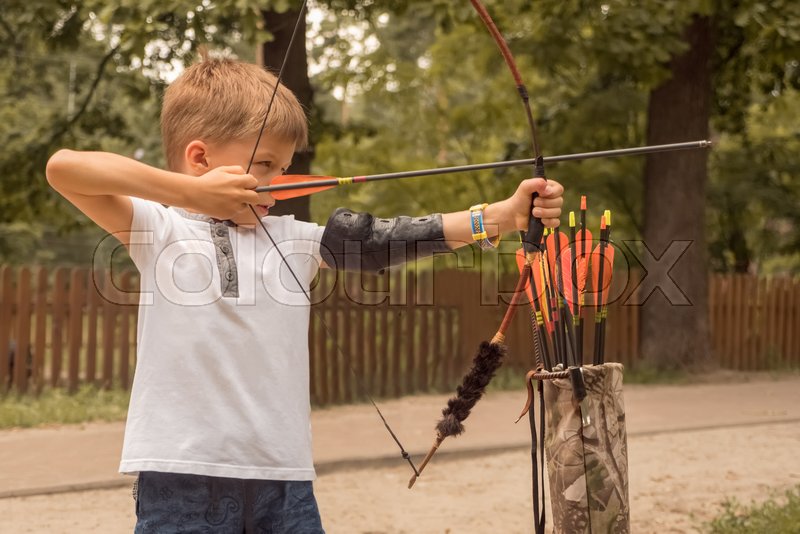 Boy with bow and arrow concentrated on Stock image Colourbox